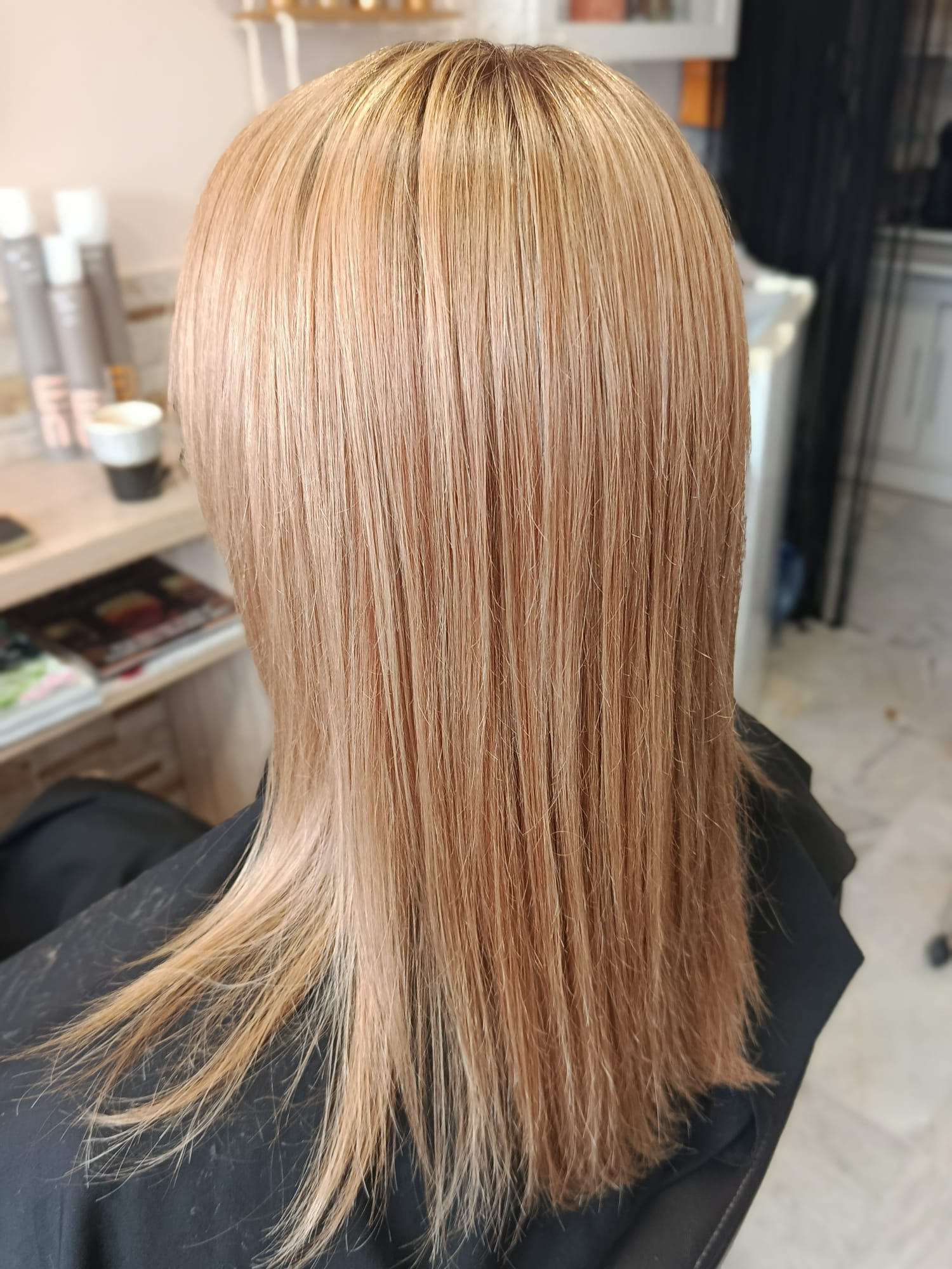Glossy golden blonde balayage on long hair with a smooth polished finish