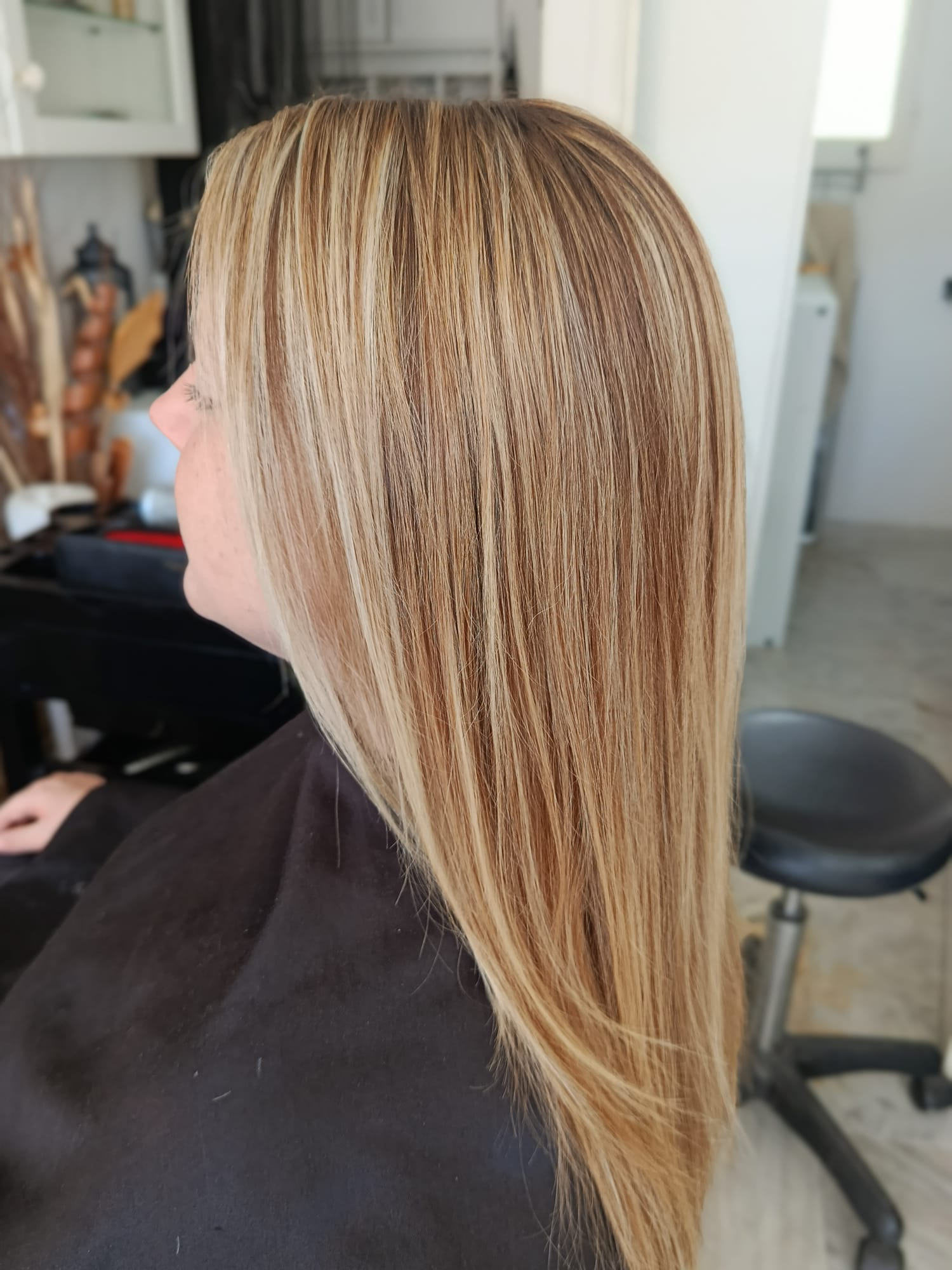 Side profile of caramel and blonde balayage on long hair
