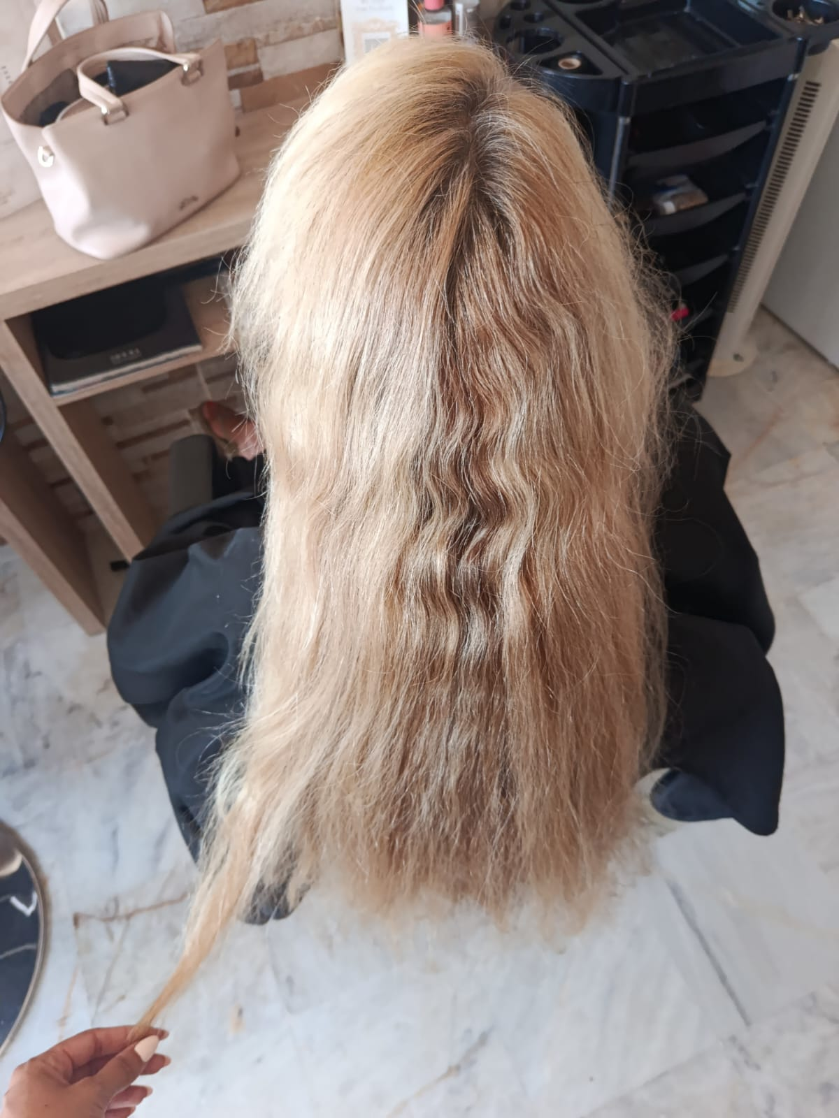 Long blonde hair with grown-out roots and dry ends before balayage highlights