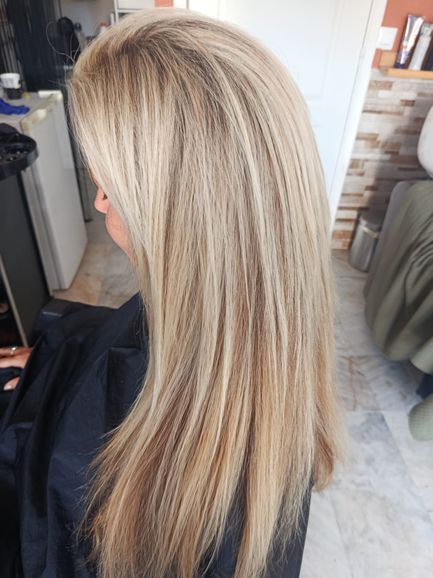 Side view of long balayage hair with bright blonde face-framing pieces