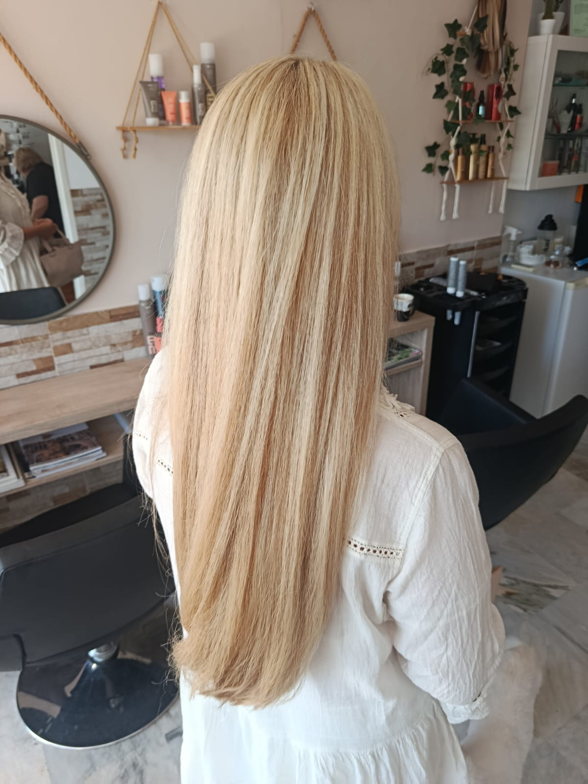 Soft hand-painted balayage highlights on long blonde hair after colour