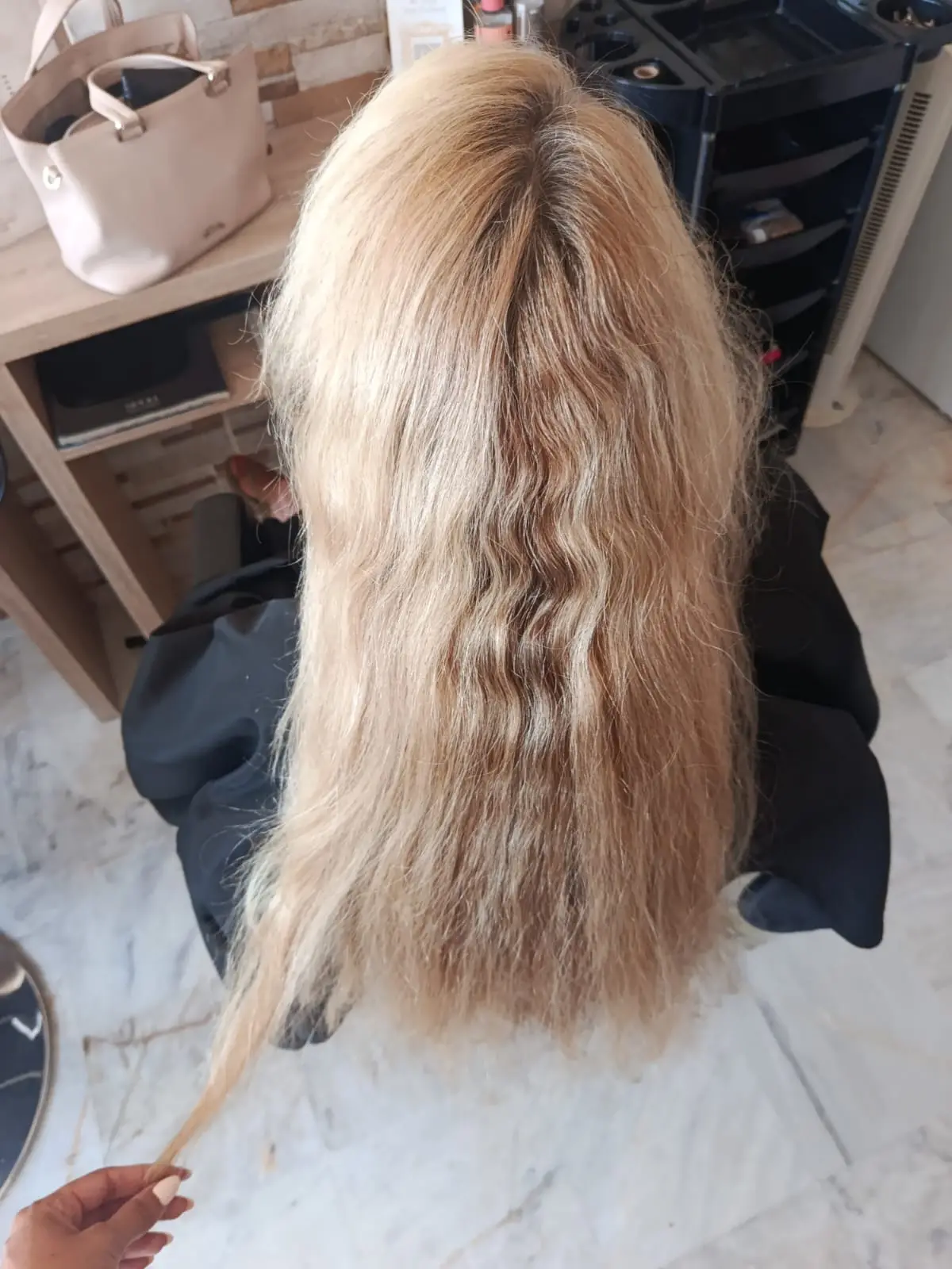 Long blonde hair with grown-out roots and dry ends before balayage highlights