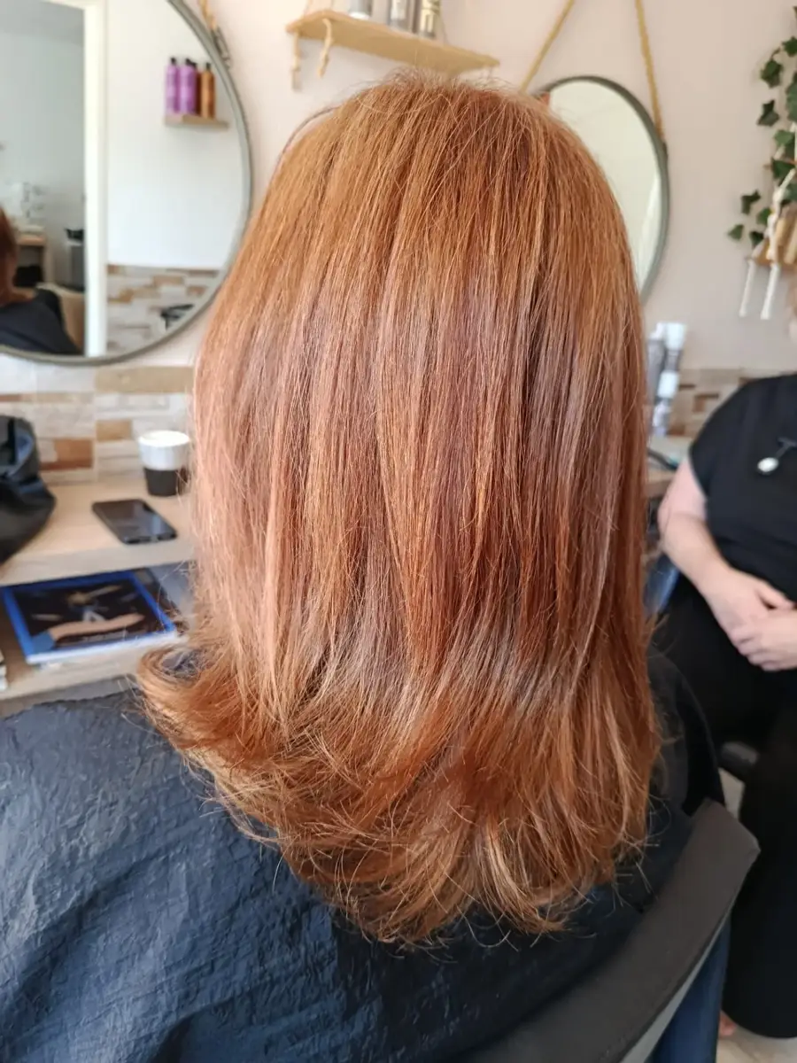 Mid-length strawberry copper hair with a soft bouncy finish